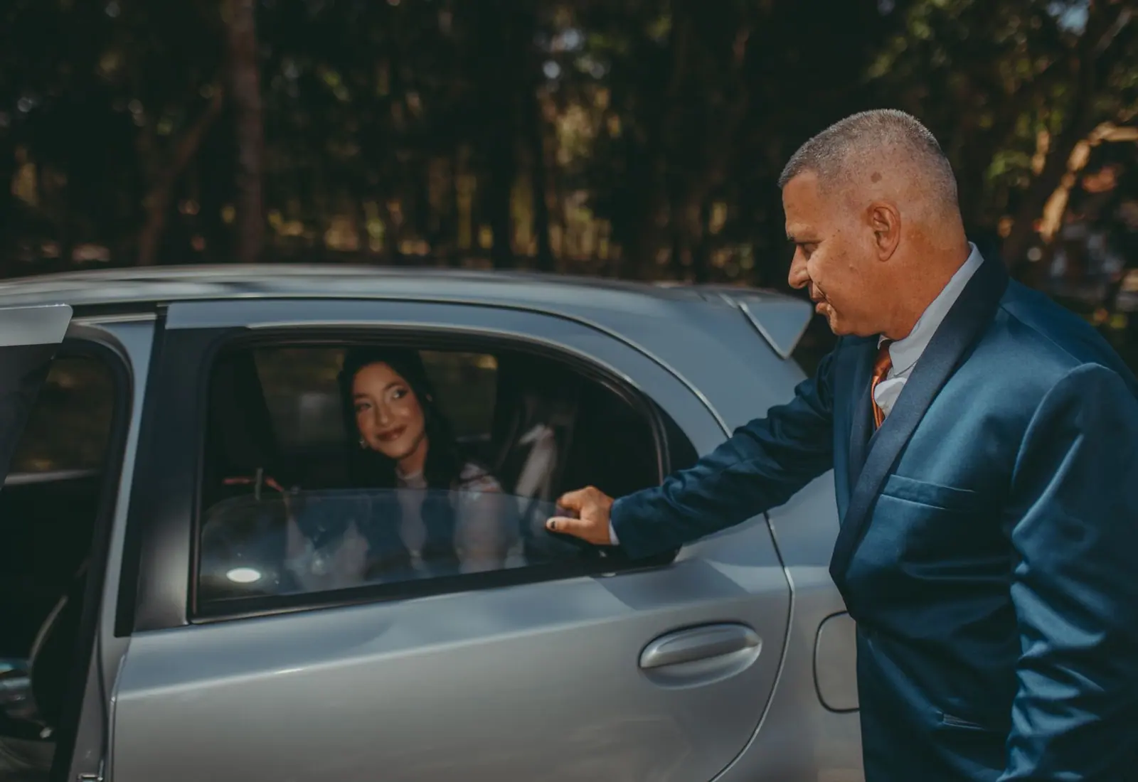 Driver holding the door open for a passenger in a chauffeur-driven cab
